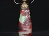 a red and green lamp with a metal base on a black background