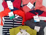 a pile of sweaters that are sitting on a table