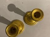pair of brass candlesticks on a white surface