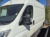 the white van is parked in the parking lot next to a tree
