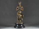bronze statue of a woman holding a bird on a pedestal