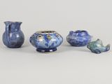 three blue vases and a small vase sitting on a table