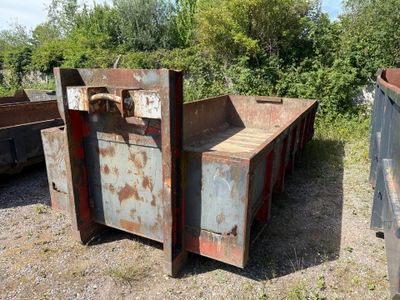 une boîte métallique rouillée posée au milieu d'un champ