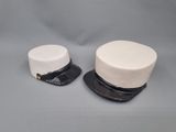 pair of white top hats with black band and buckles