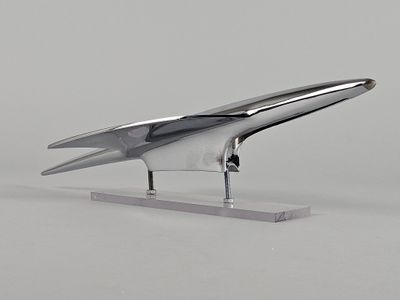 une figurine en argent représentant un oiseau, posée sur un socle