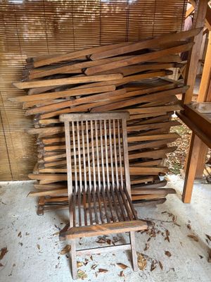 une chaise en bois posée devant un tas de bois