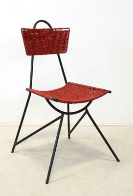 a red chair with a basket on the back of it