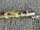 a close up of a gun on a carpet with a metal handle