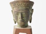 une image représentant une statue d'une tête posée sur un socle en bois