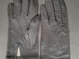 pair of black leather gloves on a gray surface