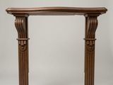 une vieille table en bois dont le plateau est sculpté sur fond blanc