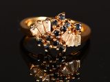 a close up of a gold ring with sapphires and diamonds