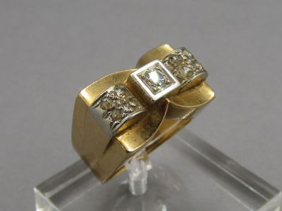 a gold and diamond ring on a clear display case