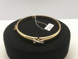 un gros plan d'un bracelet en or posé sur un chapeau noir