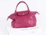 purple longchamp leather handbag on a white background