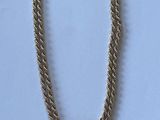 collier doré orné de pompons sur fond blanc