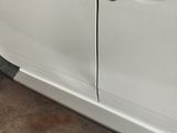 a picture of a white car with a broken door handle