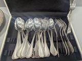 silverware in a black case on a table with a plate and bowl