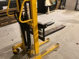 un chariot élévateur jaune garé dans un entrepôt