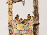 a ceramic bird fountain with birds perched on a branch
