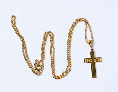 collier avec une croix et une chaîne en or sur fond blanc