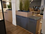 une photo d'un bureau moderne avec un bureau et des jardinières