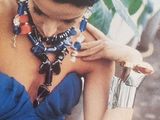a woman in a blue dress holding a silver purse