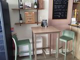a small table with two green chairs in front of it