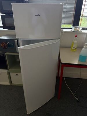 a white refrigerator and a red table in a room