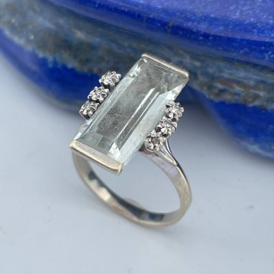 a close up of a ring with a stone on top of a rock