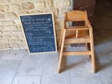 a wooden chair next to a chalk board with writing on it