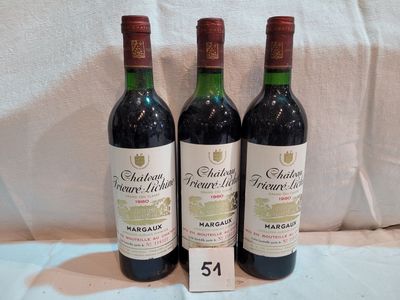 three bottles of wine sitting on top of a white sheet