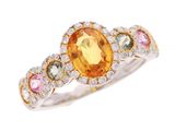 un gros plan d'une bague ornée d'un saphir jaune entouré de pierres multicolores
