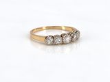 une photo d'une bague en diamant à trois pierres posée sur une surface blanche