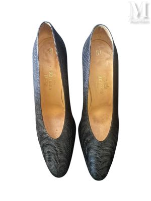 Les chaussures de cette femme sont en cuir noir et se détachent sur un fond blanc.