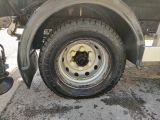 a flat tire on a flatbed truck parked on the side of the road