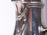 a silver tea pot sitting on top of a table