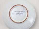 a white plate with a brown rim and writing on it