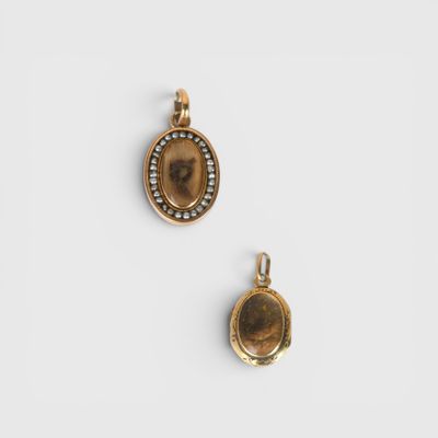 two gold lockes with a picture of a woman and a man