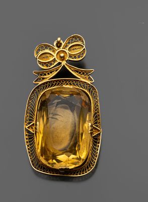 une broche en or et citrine représentant une femme portant un nœud