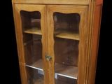 une armoire en bois avec des portes vitrées et un plateau en marbre