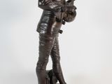 bronze statue of a man holding a guitar on a white background