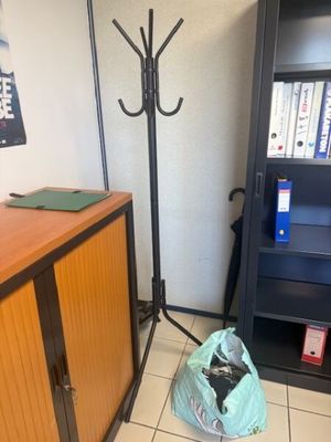 a bag of trash sitting on the floor next to a book shelf