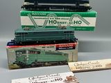 trois trains miniatures sont empilés les uns sur les autres sur une table