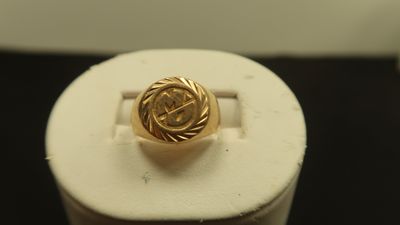 un gros plan d'une bague en or ornée d'un nœud