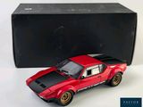 a red toy car that is next to a black box