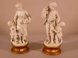 pair of white statues of a man and a woman with a child