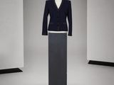 un mannequin au milieu d'un podium, vêtu d'un costume