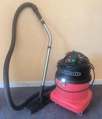 un aspirateur posé par terre à côté d'un autre aspirateur
