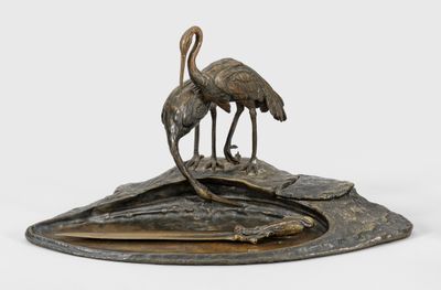 sculpture en bronze représentant deux oiseaux posés sur un rocher, sur fond blanc
